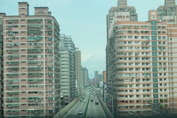 A city street with tall buildings and a mountain in the background