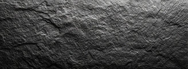 Dark gray stone texture.  Rough, uneven surface with prominent lines and grooves