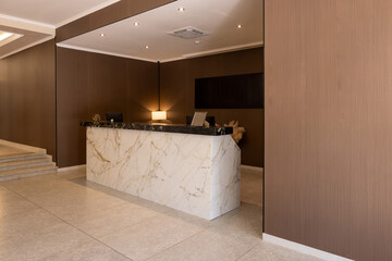Interior of a hotel lobby with a marble reception desk