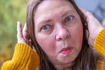 Woman covering ears with pained expression, Emotional portrait showing discomfort loud noise,...