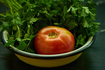 tomato and parsley are lying on a plate
