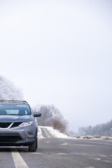 Gray Car on Snowy Road with Bare Trees