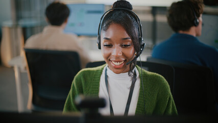 Portrait of smiling African American woman in headset working as business consultant and call center operator, helping clients with technology, sales, telemarketing, CRM and customer communication