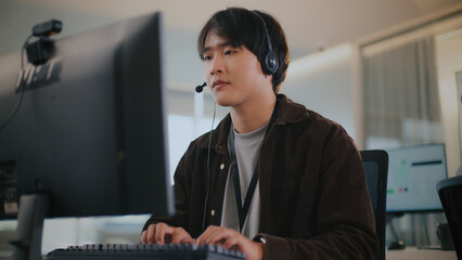 Asian business man with headset offers remote tech support, CRM help, and customer service via call...
