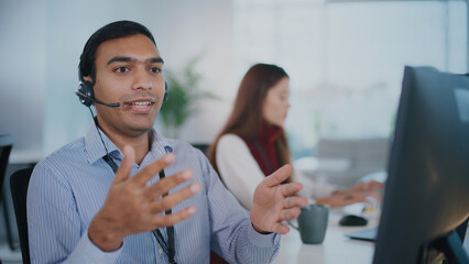 Helpful male tech support agent provides customer service at call center. Focused operator wearing...