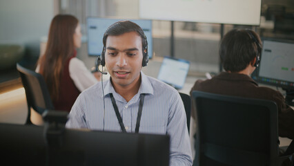 Corporate customer service team including Indian business man and black woman in headset,...