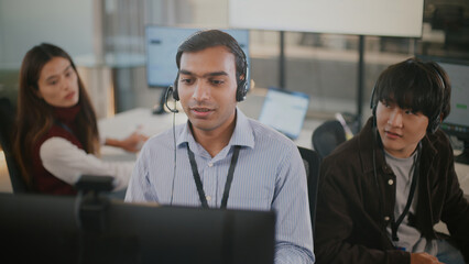 Confident Indian businessman provides customer service and tech support in a diverse corporate...