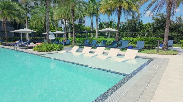 Empty luxury swimming pool with in-water loungers in Doral, Florida