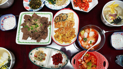 Traditional Korean New Year’s Feast Featuring Nabak Kimchi, Jeotgal, Kimchi, Rice Cake Soup, and Namul