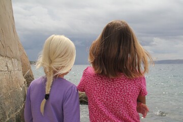 Two Young Girls Looking at the Sea on a Cloudy Day