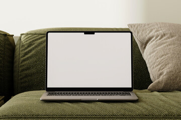 Blank screen laptop on the modern green couch in living room background