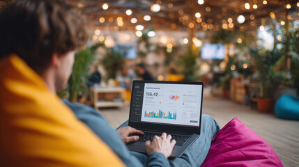 Person working on a laptop with data charts in a cozy, modern workspace. Depicts flexibility, remote work, digital lifestyle and business insights. Ideal for tech, finance.