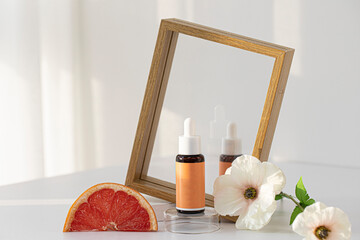 A bottle of natural cosmetic product and grapefruits with a frame
