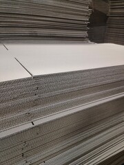 Sheets of corrugated cardboard are carefully cut and prepared for the manufacture of boxes.