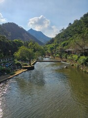 A picture of a small river and a mountain in a Chinese village