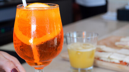 Enjoying a Refreshing Spritz Cocktail in a Lively Bar Setting Discover the Vibrant Flavors and...