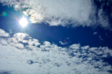 niebieskie niebo z białymi chmurami i słońcem, tło z błekitnym niebem i delikatnymi chmurami, miejsce na tekst, blue sky with white clouds, background with blue sky and white clouds,  space for text © kateej
