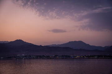 sunset over the red sea with mountains in the background 