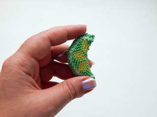 A hand of adult holding beading key chain on white background