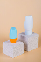 Cosmetic product in tube, bottle, lotion or serum with stylish props on cream background. 