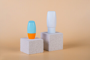 Cosmetic product in tube, bottle, lotion or serum with stylish props on cream background. 