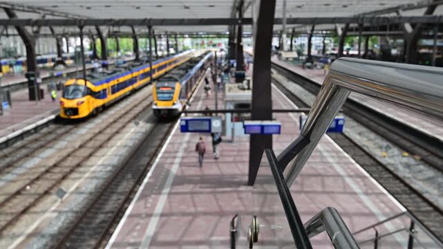 Rotterdam Netherlands July 12 2025. Selective focus. Yellow and blue NS trains on the platform of Rotterdam Central Station with passengers and modern canopy.
