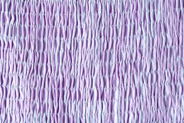 Close-up texture of smocked fabric, showcasing its parallel rows and delicate stitching in shades...