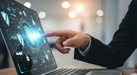 Close up of a hand touching a laptop screen with a digital interface showing a shield, representing cybersecurity and data protection