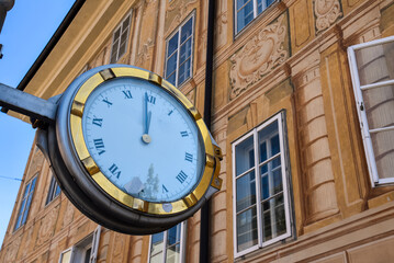 An elegant street clock against a beautifully painted Baroque-style fa&ccedil;ade in Innsbruck, Austria.