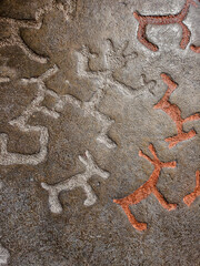 The background is a rock drawing of ancient people close up