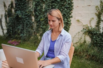 Young Woman Working on Laptop in Garden