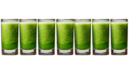 Six glasses filled with vibrant green juice line a dark surface