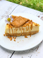 Biscoff Cheesecake with biscoff biscuit and edible flower on top