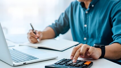 Doing finance, budgeting and tax calculation. Close up woman hand using calculator to calculate home finance, accounting with laptop computer on table, budget management, monthly expenses.
