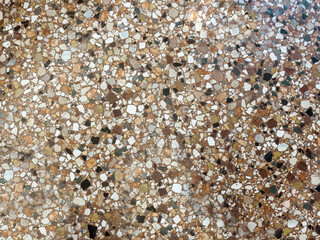 Vintage terrazzo flooring with multicolored marble chips and brown base, classic Italian-style old interior surface texture