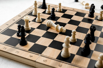 White chess king laying down on chessboard after checkmate
