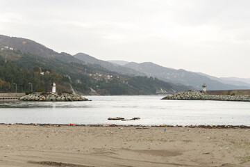view from the pier to the bay of the Black sea and the mountains and plastic waste on the beach,...