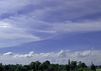 Beautiful blue sky with clouds and forest canopy with old brickline chimneys