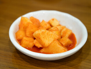 Spicy Korean Radish Kimchi in a Black Bowl