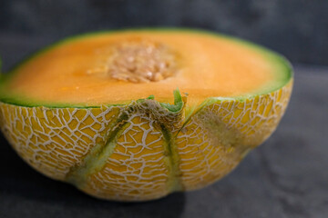 Ripe cantaloupe cut in half revealing juicy, sweet flesh and textured rind