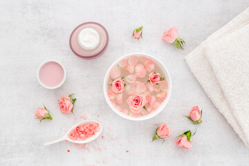 Spa and beauty routine concept with pink roses and essence water with petals