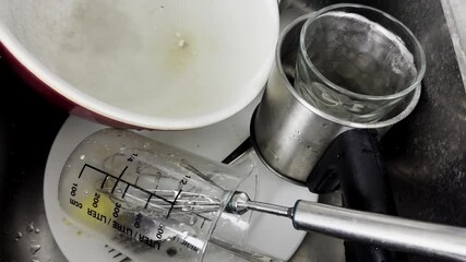 Dirty dishes in sink after baking, overhead camera zoom for real-life kitchen scenes, ideal for cooking blogs, cleanup tutorials, or recipe endings