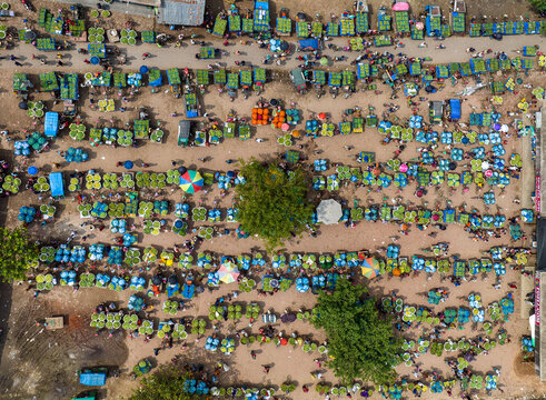 Kansat, Bangladesh - 15 June 2019: Aerial view of the bustling Sona Masjid Road market, where vendors display their produce in vibrant green and red hues, creating a lively scene.