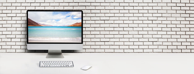Computer with beach and ocean on screen monitor on white table Isolated in clipping path. free...