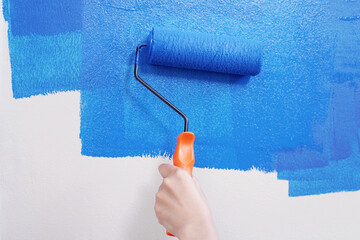 Roller Brush Painting, Worker painting on surface wall Painting apartment, renovating with blue...