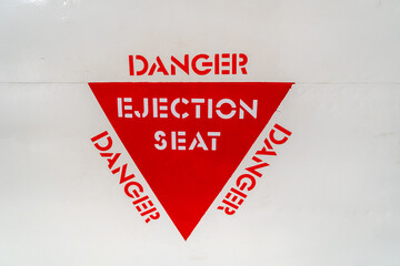 Ejection seat warning sign on an old aircraft fuselage close-up