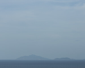 Distant Islands on the Horizon over Calm Blue Sea

