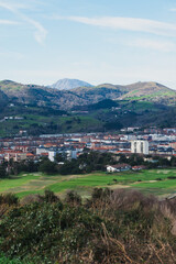 Naklejka premium Scenic view of Zarautz with lush hills and modern architecture under clear sky