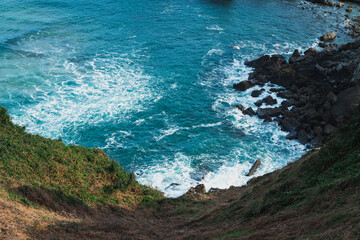 Waves crashing against rocky coastline in Zarautz on a sunny day