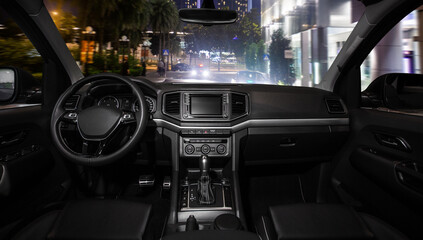 A black car with a dark interior and a large screen on the dashboard